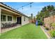 Backyard with artificial grass, playhouse, patio area, and string lights, creating a welcoming outdoor space at 2433 Amatrice St, Henderson, NV 89044