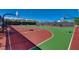 Community basketball court with multiple hoops, green and red playing surfaces and benches for players at 2433 Amatrice St, Henderson, NV 89044