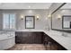 Bathroom featuring dual sinks, elegant mirrors, soaking tub, decorative lighting, and tiled floors at 2433 Amatrice St, Henderson, NV 89044