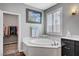 Bathroom with soaking tub, walk-in closet access, and modern fixtures at 2433 Amatrice St, Henderson, NV 89044