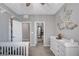 Well-lit bedroom with a dresser and carousel wall decoration, leading to a closet at 2433 Amatrice St, Henderson, NV 89044