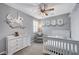 Serene bedroom with a teddy bear, crib, comfortable chair, and carousel decoration at 2433 Amatrice St, Henderson, NV 89044