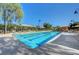 A refreshing community pool under a clear blue sky, surrounded by comfortable lounge chairs and lush greenery at 2433 Amatrice St, Henderson, NV 89044