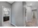 Hallway leading to a bathroom and closet, featuring neutral tones and tiled flooring at 2433 Amatrice St, Henderson, NV 89044