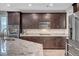 Well-equipped kitchen with dark cabinets, stainless appliances and granite countertops at 2433 Amatrice St, Henderson, NV 89044