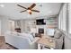 Bright living room boasts a ceiling fan, fireplace, built-in shelves and grey couches with throw pillows at 2433 Amatrice St, Henderson, NV 89044