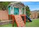 Detailed view of the backyard playhouse with climbing wall, slide, and a charming design at 2433 Amatrice St, Henderson, NV 89044