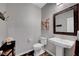 Stylish powder room featuring a pedestal sink, dark-trimmed mirror, and modern fixtures at 2433 Amatrice St, Henderson, NV 89044