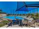 Community swimming pool featuring blue water, comfortable seating, sunshades, and well-manicured landscaping at 2433 Amatrice St, Henderson, NV 89044