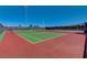 Community tennis court featuring a green playing surface with a red surround and a tall net and fence at 2433 Amatrice St, Henderson, NV 89044
