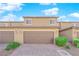 Townhome with a brick driveway, two car garage and manicured bushes at 3064 Bicentennial Pkwy, Henderson, NV 89044