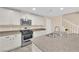 Kitchen offers granite countertops, stainless steel appliances, and white cabinets with dark hardware at 3064 Bicentennial Pkwy, Henderson, NV 89044