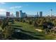 Scenic aerial view of a lush golf course with bunkers and city buildings in the background at 3111 Bel Air Dr # 20H, Las Vegas, NV 89109