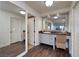 Well-lit bathroom vanity with modern fixtures, wood-look tile flooring, and ample cabinet space at 3111 Bel Air Dr # 20H, Las Vegas, NV 89109