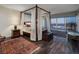 Beautiful bedroom with a four-poster bed, wood floors, balcony access, and city views at 3111 Bel Air Dr # 20H, Las Vegas, NV 89109