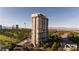 High-rise exterior featuring a pool, tennis court, desert landscaping, and the city skyline in the background at 3111 Bel Air Dr # 20H, Las Vegas, NV 89109