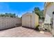 Property features a storage shed and equipment on a paved surface, enclosed by brick walls and shrubbery at 3360 Paso Andres St, Las Vegas, NV 89146