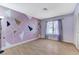 Bedroom features laminate floors, artist painted accent wall and window at 3360 Paso Andres St, Las Vegas, NV 89146