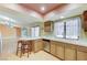 Bright kitchen featuring breakfast bar, laminate floor, and stainless dishwasher overlooking the adjacent room at 3360 Paso Andres St, Las Vegas, NV 89146