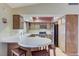 Charming kitchen with breakfast bar, wooden cabinets, stainless steel appliances, and laminate flooring at 3360 Paso Andres St, Las Vegas, NV 89146