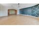 Spacious living room with modern accent wall, light hardwood floors, and elegant archway at 3360 Paso Andres St, Las Vegas, NV 89146