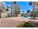 View of the pool, spa, and brick patio area in the backyard, complemented by landscaping at 3360 Paso Andres St, Las Vegas, NV 89146