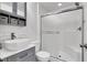 Contemporary bathroom with a white vanity, framed mirror, and walk-in shower with a glass door at 382 Gracious Way, Henderson, NV 89011