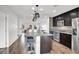 Open-concept kitchen with a central island, stainless steel appliances, granite counters, and a view into the living area at 382 Gracious Way, Henderson, NV 89011