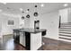 Open kitchen with granite island, modern pendant lighting, dark cabinets, and wood floors, perfect for entertaining at 382 Gracious Way, Henderson, NV 89011