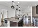 Bright open kitchen with granite counters, stainless appliances, dark cabinetry, and stylish pendant lighting overlooking living area at 382 Gracious Way, Henderson, NV 89011