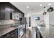 Modern kitchen featuring dark cabinets, granite countertops, stainless steel appliances, and stylish pendant lighting at 382 Gracious Way, Henderson, NV 89011
