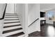 Staircase with wood treads, white risers, and black handrail leading to the upper level of the home at 382 Gracious Way, Henderson, NV 89011