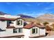 View of white stucco home with a terracotta tile roof, with green shutters and mountain views at 4 Lomita Heights Dr, Las Vegas, NV 89138