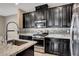 Close-up of the kitchen with stainless steel appliances and dark cabinets against mosaic backsplash at 4 Lomita Heights Dr, Las Vegas, NV 89138