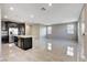 Open concept view of the kitchen and living room with dark cabinets and stainless steel appliances at 4 Lomita Heights Dr, Las Vegas, NV 89138