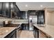 Close-up kitchen with stainless steel appliances against dark cabinets and mosaic tile backsplash at 4 Lomita Heights Dr, Las Vegas, NV 89138