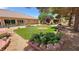 This private backyard has desert landscaping, mature trees and lush lawn space at 4650 Stoneham St, Pahrump, NV 89061