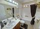 Well-lit bathroom with tile flooring, a single sink vanity, and a shower-tub combination with neutral curtains at 4650 Stoneham St, Pahrump, NV 89061