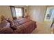 Bedroom with a window, closet, and a comfortable bed with decorative pillows and a patterned comforter at 4650 Stoneham St, Pahrump, NV 89061