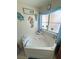 Bathroom with jacuzzi tub, nautical decor, and natural light from the window at 4650 Stoneham St, Pahrump, NV 89061