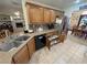 Kitchen area with stainless appliances, wood cabinets, stone countertops, and a view to the dining room at 4650 Stoneham St, Pahrump, NV 89061