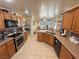 Open kitchen with stainless appliances, wood cabinets, granite counters, and an opening to the bedroom at 4650 Stoneham St, Pahrump, NV 89061