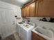 Functional laundry room with appliances, upper cabinets, a utility sink, and a door to the outside at 4650 Stoneham St, Pahrump, NV 89061