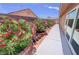Well maintained side yard featuring colorful flowers and a concrete walkway alongside the house at 4650 Stoneham St, Pahrump, NV 89061