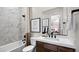 Elegant bathroom with marble tile, modern fixtures, and a tub with a shower at 490 Carter House Ave, Las Vegas, NV 89138