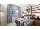 Comfortable bedroom with a sports theme, featuring a modern bed, window with mountain views, and stylish decor at 490 Carter House Ave, Las Vegas, NV 89138