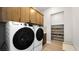 Well-equipped laundry room with modern washer, dryer, upper cabinets and adjacent shelving at 490 Carter House Ave, Las Vegas, NV 89138