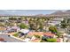 Aerial view showcases a desert neighborhood with houses, palm trees, and mountain views at 4916 Carmichael Ave, Las Vegas, NV 89110