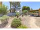Landscaped backyard with gravel, bushes, and covered patio with table and chairs at 4916 Carmichael Ave, Las Vegas, NV 89110