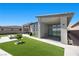 Modern backyard features a lawn, a fire pit and a covered patio with a fireplace at 5166 Stone View Dr, Las Vegas, NV 89135